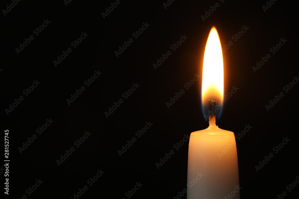Burning candle on dark background, space for text. Symbol of sorrow Burning candle on dark background, space for text. Symbol of sorrow