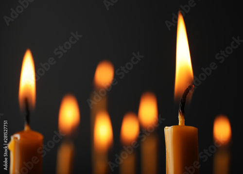 Tela Burning candles on dark background, space for text