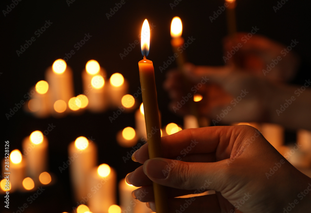 Φωτογραφία Woman holding burning candle in darkness against blurred background, closeup