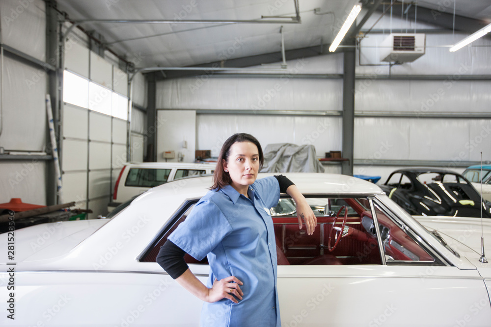 Portrait of mechanic leaning on car in automobile repair shop Portrait of mechanic leaning on car in automobile repair shop