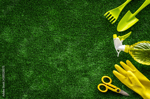 Gardening tools on green grass background top view mock up