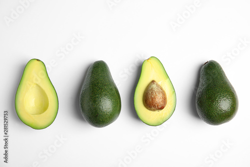 Cut and whole fresh ripe avocados on white background, top view
