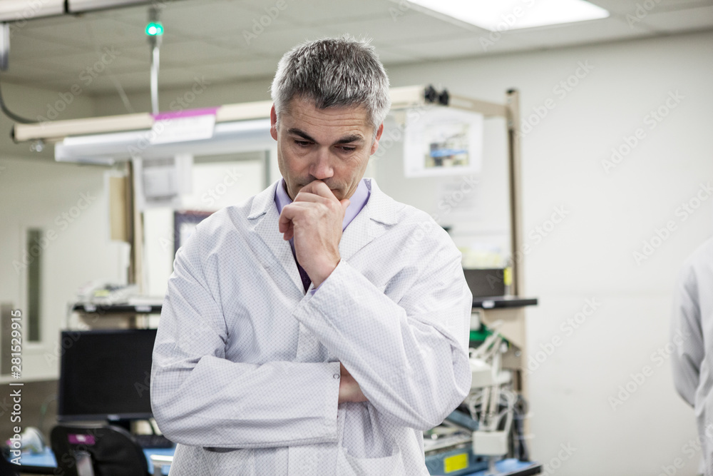 Thoughtful technician standing in laboratory