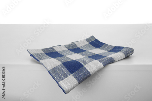 Folded kitchen towel on light table against white background