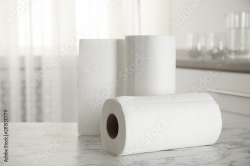Rolls of paper towels on white marble table in kitchen, space for text