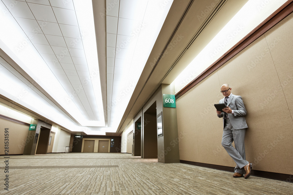 Businessman using digital tablet in corridor Businessman using digital tablet in corridor