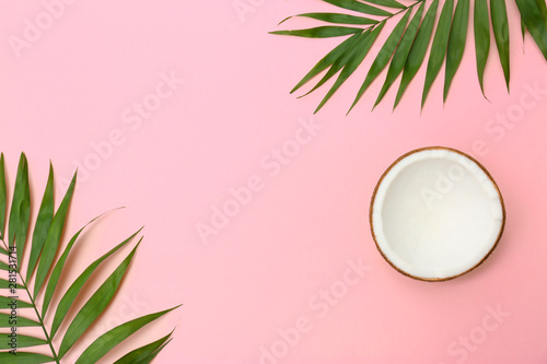 Fresh coconut and palm leaves on pink background, flat lay. Space for text