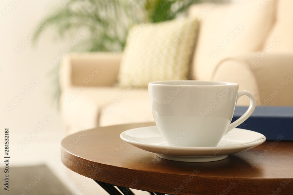 Cup of coffee and book on table in room Cup of coffee and book on table in room