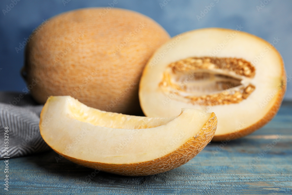 Tasty cut ripe melon on blue wooden table