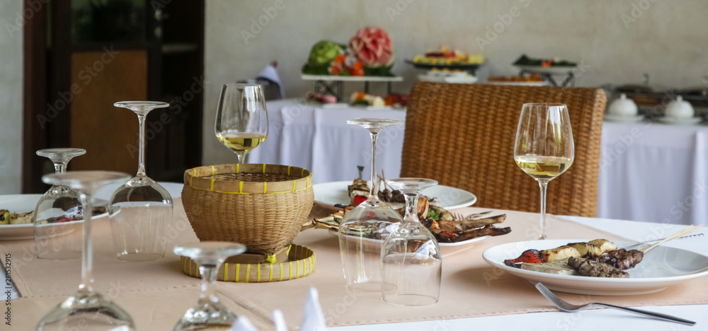 Banquet table with food and wine glasses. Table arranged for a dinner event Banquet table with food and wine glasses. Table arranged for a dinner event