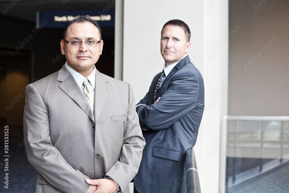 Portrait of businessmen standing in convention center Portrait of businessmen standing in convention center