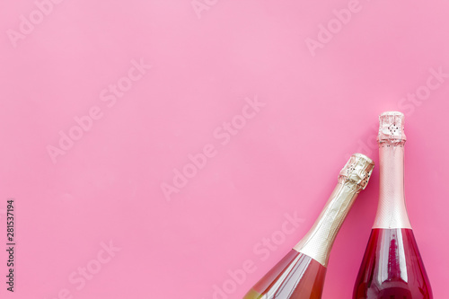 Champagne bottle for celebration on pink background top view mock up © 9dreamstudio