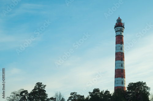 High lighthouse in the forest landscape. red and white lighthouse