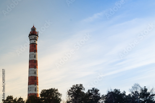 High lighthouse in the forest landscape. red and white lighthouse