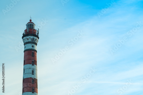 High lighthouse in the forest landscape. red and white lighthouse