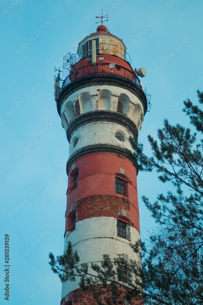 Lighthouse in the forest among the trees. red and white lighthouse Lighthouse in the forest among the trees. red and white lighthouse