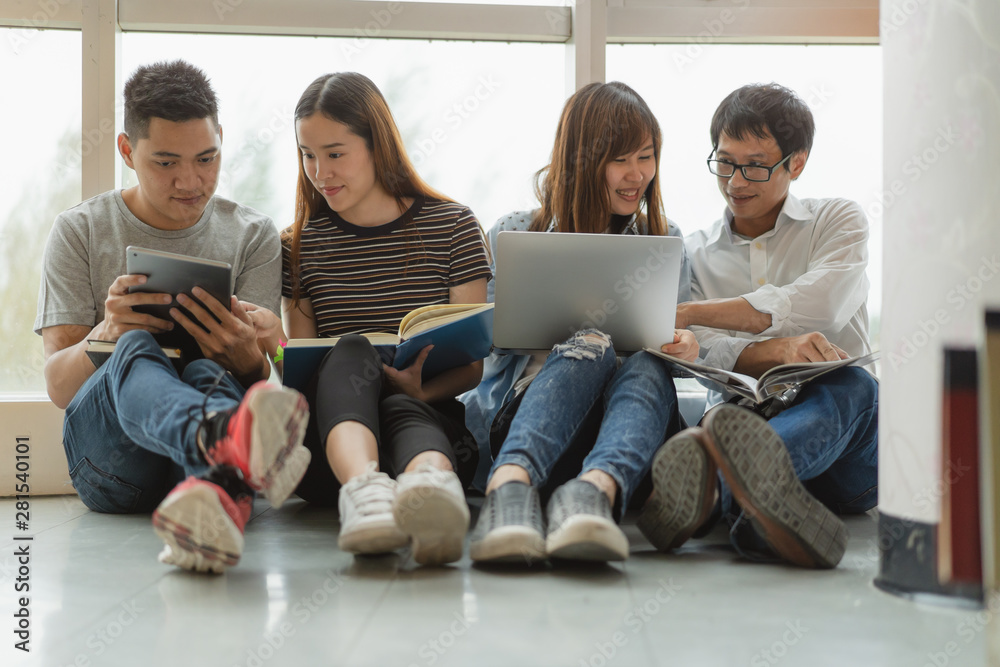 Group of asian students researching data for homework assignment in library. Group of asian students researching data for homework assignment in library.