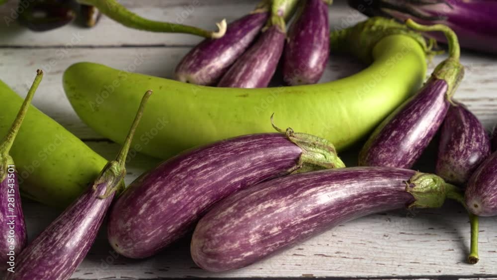 Extreme close up of fairy tale eggplants on a wood table, camera sliding to the right. Extreme close up of fairy tale eggplants on a wood table, camera sliding to the right.