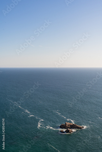 Small rock island isolated on a large ocean landscape