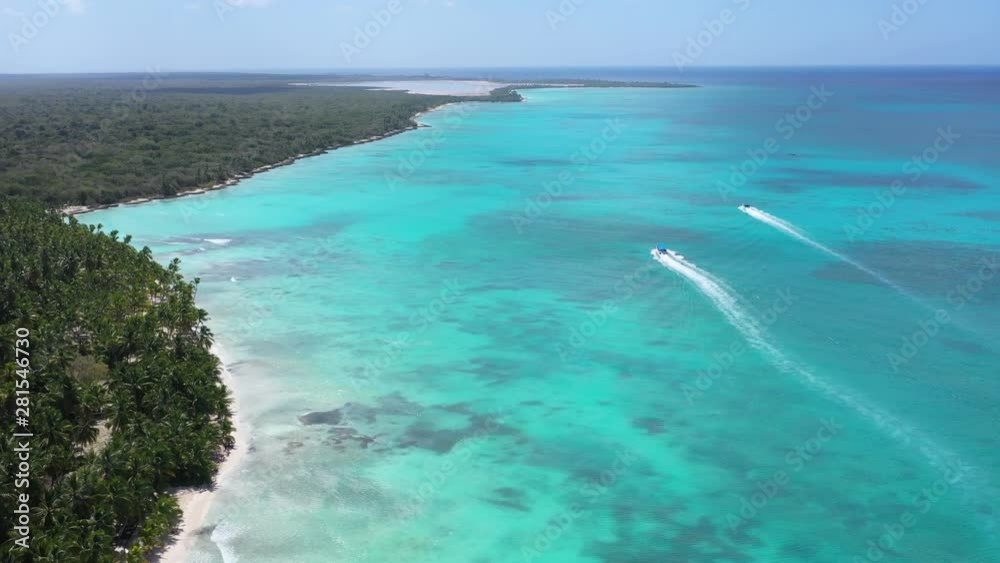 Aerial view from drone on tropical shore with coconut palm trees and boats floating in turquoise caribbean sea. Travel destinations. Summer vacations Aerial view from drone on tropical shore with coconut palm trees and boats floating in turquoise caribbean sea. Travel destinations. Summer vacations