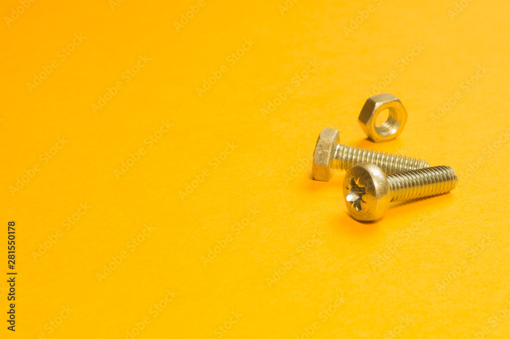 Steel screw on a yellow background Steel screw on a yellow background