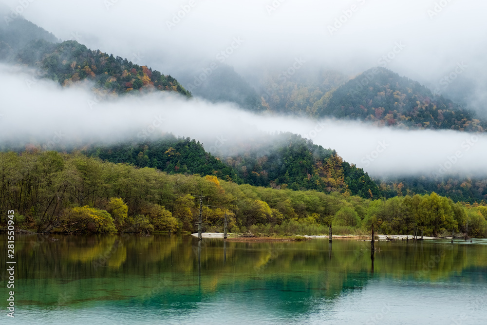 Lake Taisho ,Hotaka mountain range with misty in morning time, water reflection. the lake is located in Kamikochi national park ,the Northern Alps of the Japanese Alps in Japan.