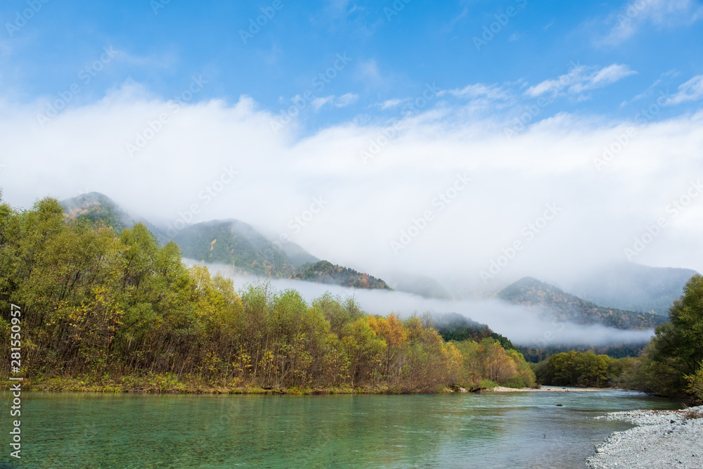 Lake Taisho view point in autumn season, water reflection and blue clouds sky in morning time in Kamikochi national park, Japan.