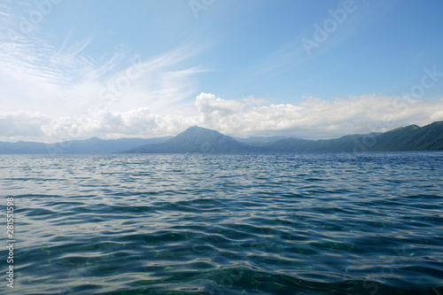 Mountain lake view in good weather morning time on blue clouds sky background.