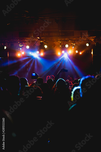 Tel Aviv, Israel February 23, 2018: Yellow, blue and red lights at a concert with people in the foreground