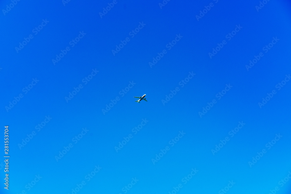Airplane centered on a bright blue sky