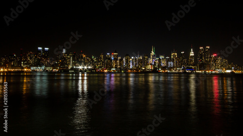 Manhattan skyline at night with reflections off water New York City NYC © stockelements