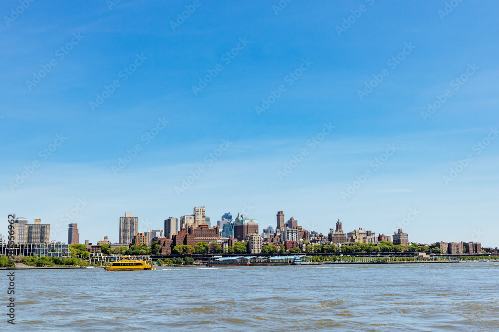 A view of Brooklyn from lower Manhattan with a water taxi in the distance