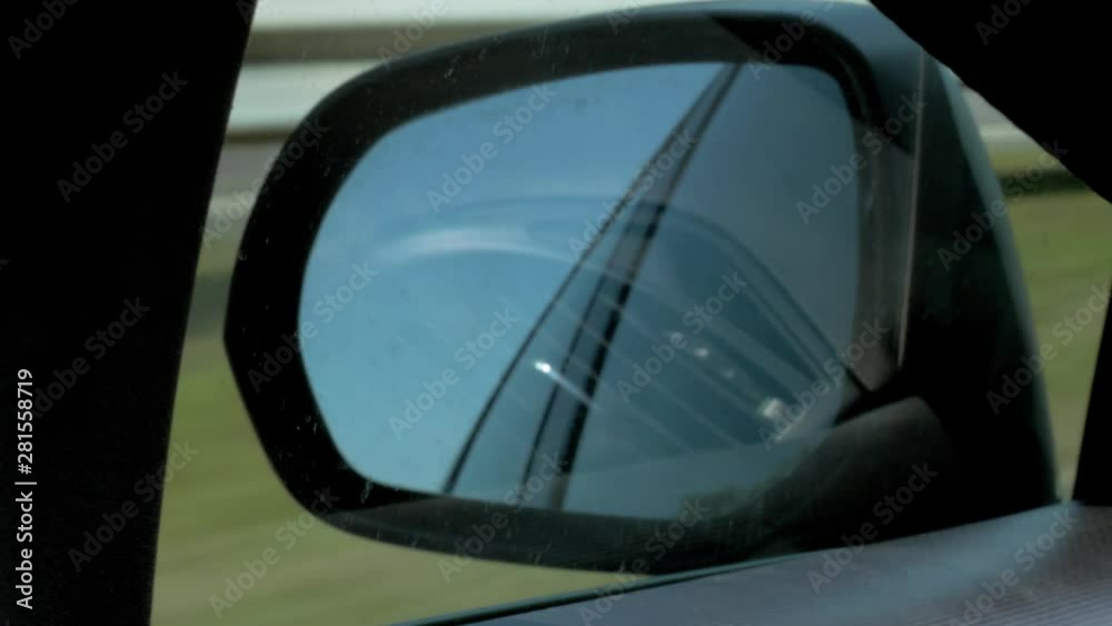 Rear view mirror of the car while driving on the highway Rear view mirror of the car while driving on the highway