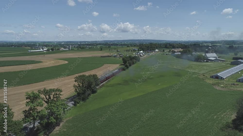 Aerial View of Farmlands and Countryside with a Vintage Steam Train Puffing Along on a Sunny Summer Day Aerial View of Farmlands and Countryside with a Vintage Steam Train Puffing Along on a Sunny Summer Day