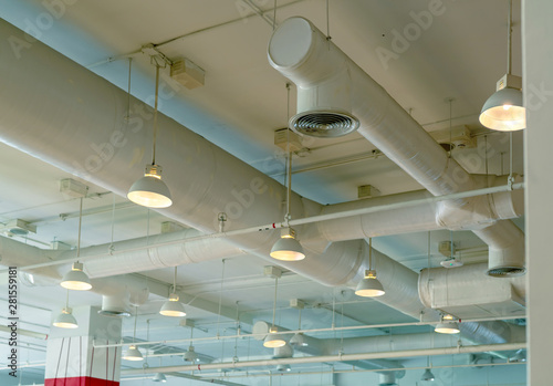 Air duct, wiring and plumbing in the mall. Air conditioner pipe, wiring pipe, and plumbing pipe system. Ceiling lamp light with opened light. Building interior concept. Interior architecture concept.