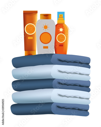 Sun bronzers bottles on towels piled up