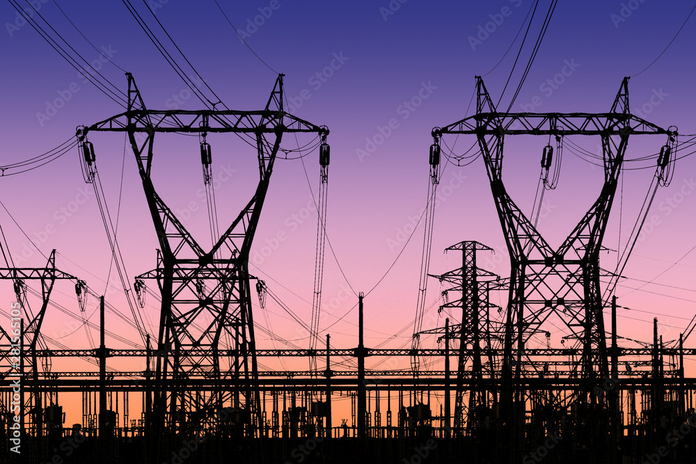 high voltage pylons silhouette , sunset lighting, clear sky background