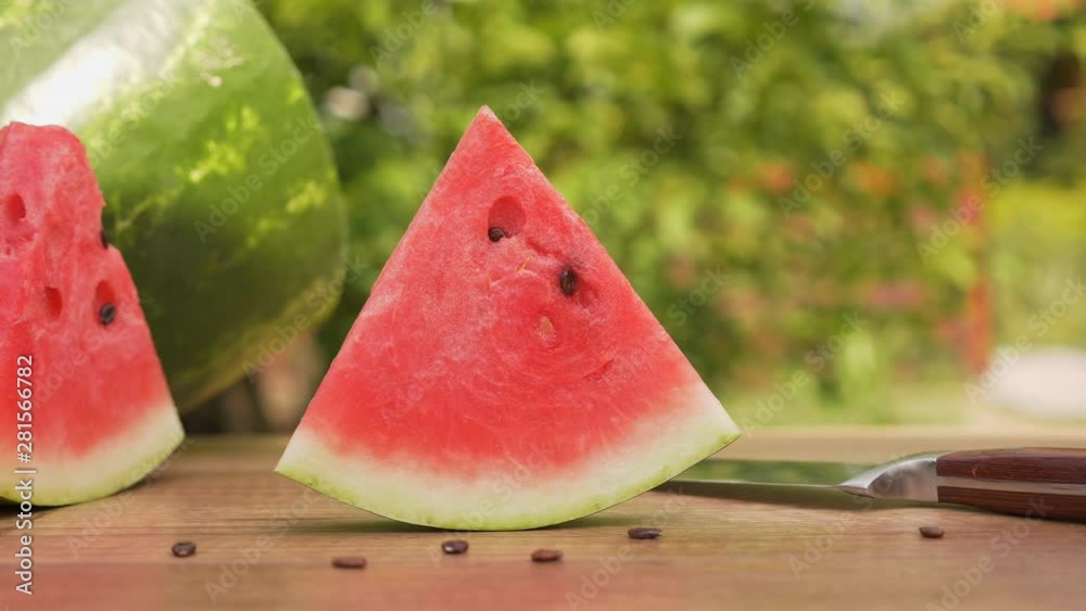 Red watermelon slice on the table. Summer refreshing fruit close up with seeds around. Red watermelon slice on the table. Summer refreshing fruit close up with seeds around.