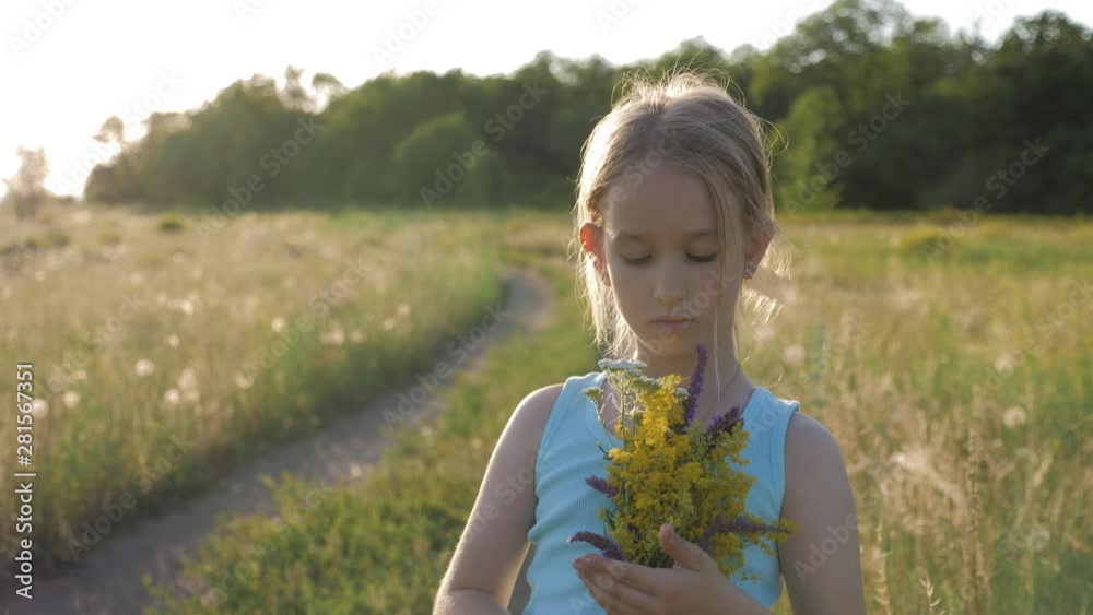 Cute little girl running in a meadow in the colors of a flowers. Carefree childhood - little child girl play on summer green meadow grass with flowers. Cute little girl running in a meadow in the colors of a flowers. Carefree childhood - little child girl play on summer green meadow grass with flowers.