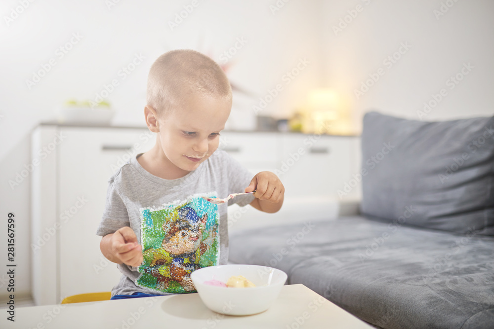 Kid eating icecream in the living room. Kid eating icecream in the living room.