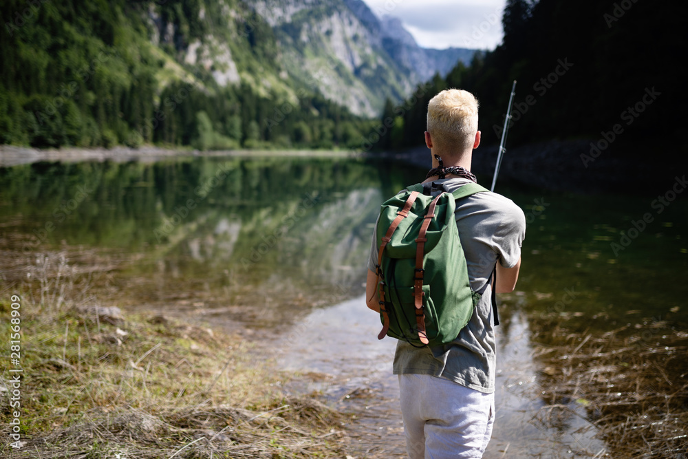 Fisherman fishing in nature at lake while camping outdoor Fisherman fishing in nature at lake while camping outdoor