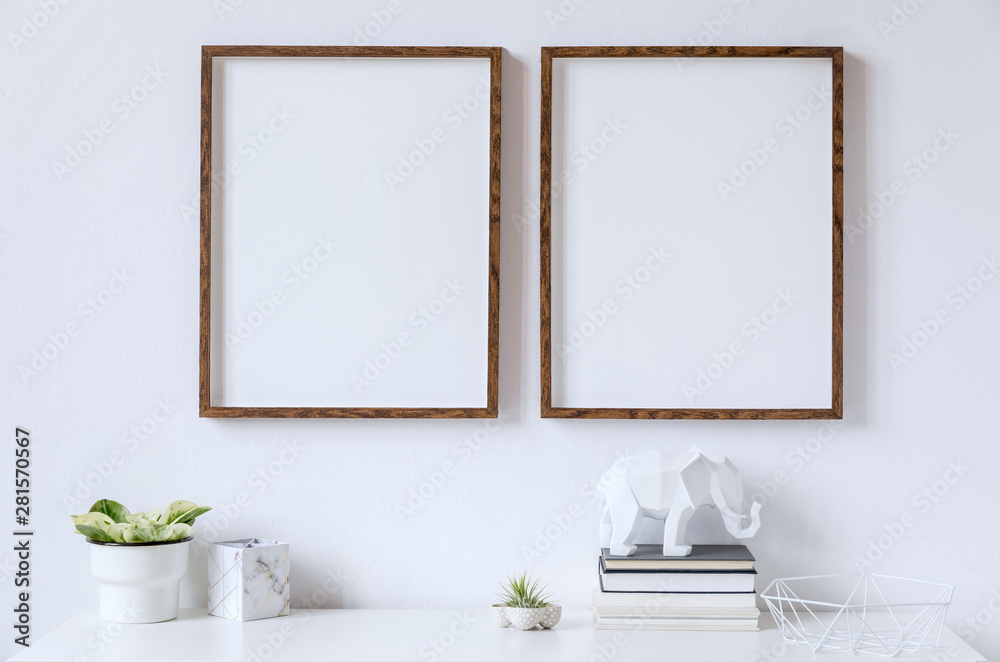 Stylish white home decor of interior with two brown wooden mock up photo frames on the white shelf with books, beautiful plant in stylish pot, elephant figure and home accessories. Stylish white home decor of interior with two brown wooden mock up photo frames on the white shelf with books, beautiful plant in stylish pot, elephant figure and home accessories.