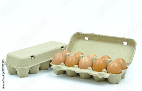 Isolated of ten chicken eggs in brown paper cardboard container nearby the other close box on white background with copy space on the upper .