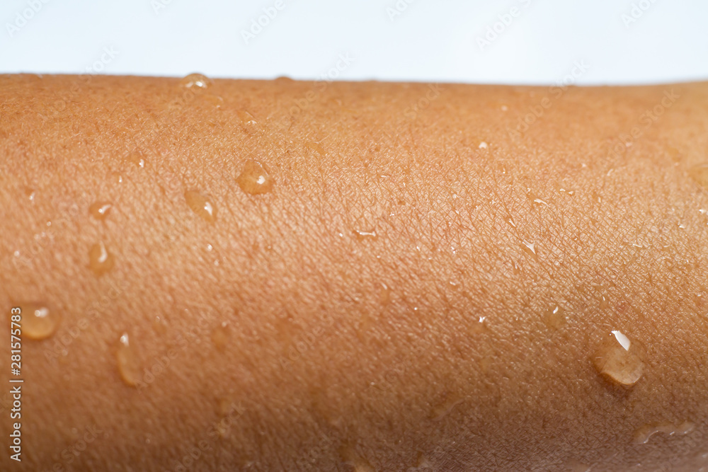 Fototapeta premium Woman's wet arm with water drops on white acrylic background, Close up & Macro shot, Selective focus, Asian Body skin part, Relaxing Bath, Healthcare concept