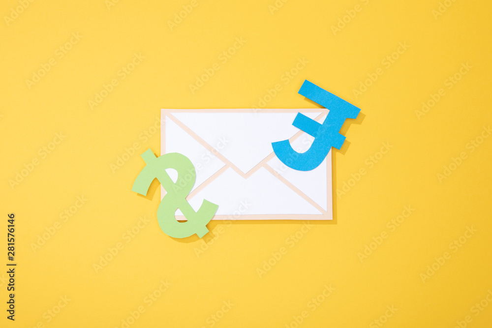 top view of paper icons of envelope and types of currency on yellow top view of paper icons of envelope and types of currency on yellow