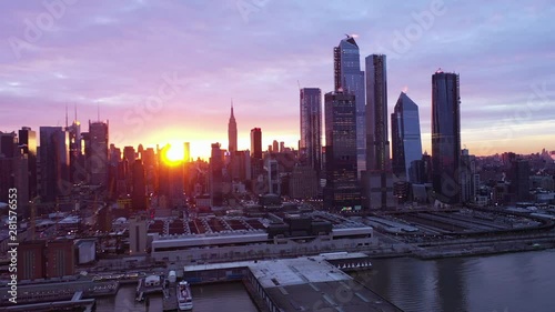 Right to left aerial midtown west water front cityscape and cloudscape; beautiful sky; colourful; sunrise; sun flare; Empire State Building photo