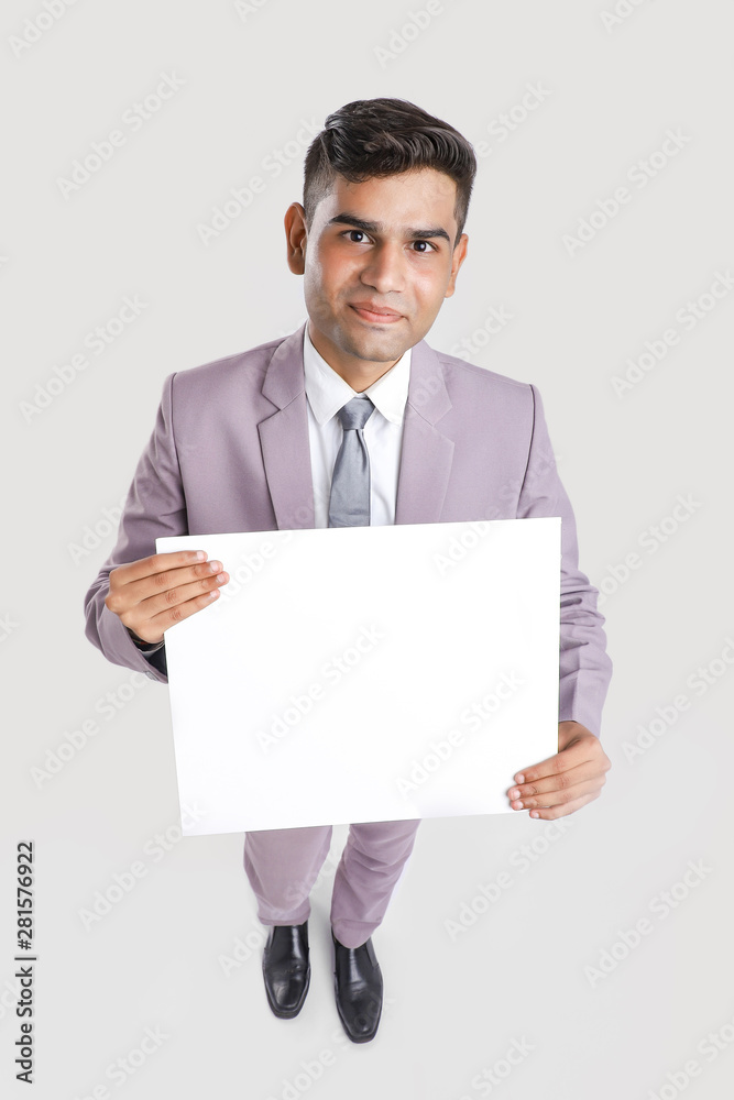 Young Indian business executive showing blank sign board over white background Young Indian business executive showing blank sign board over white background