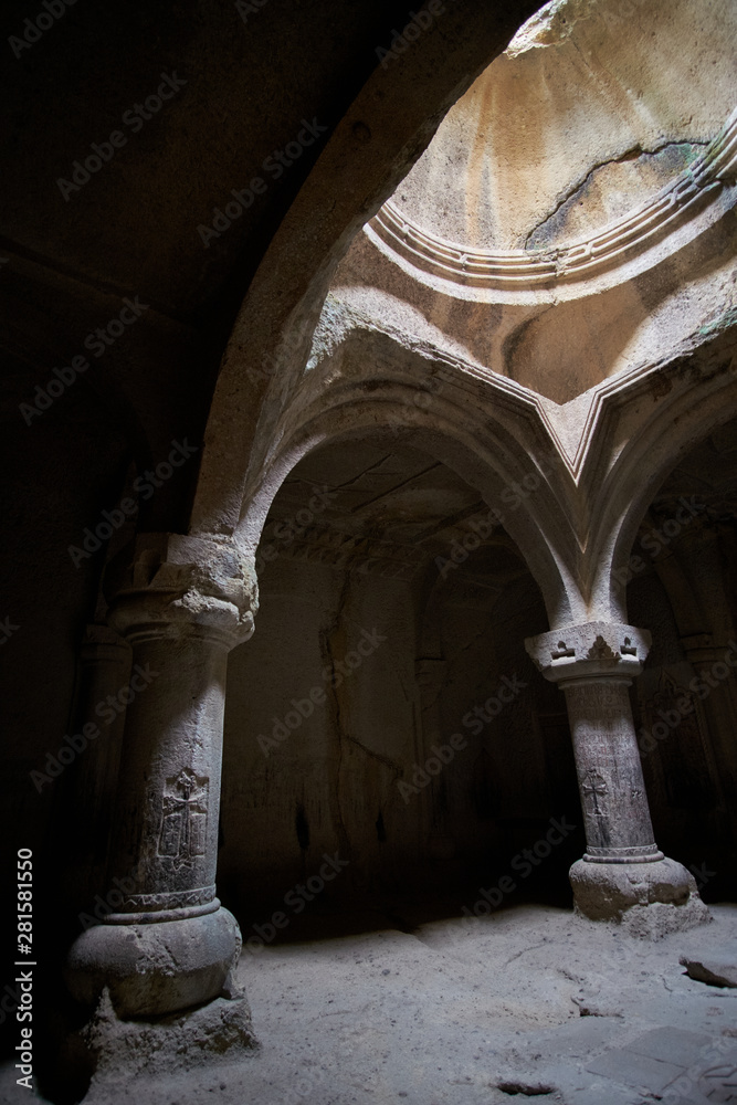 The columns of the ancient temple, illuminated through the windows, are carved with religious symbols on the walls.