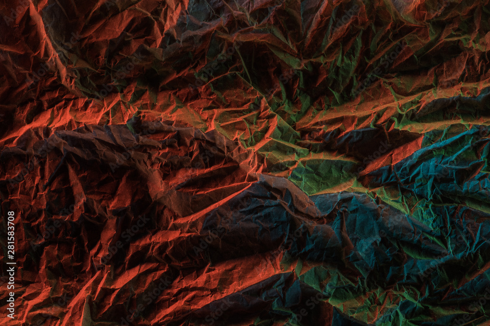 top view of crumpled paper with colorful lighting in dark top view of crumpled paper with colorful lighting in dark