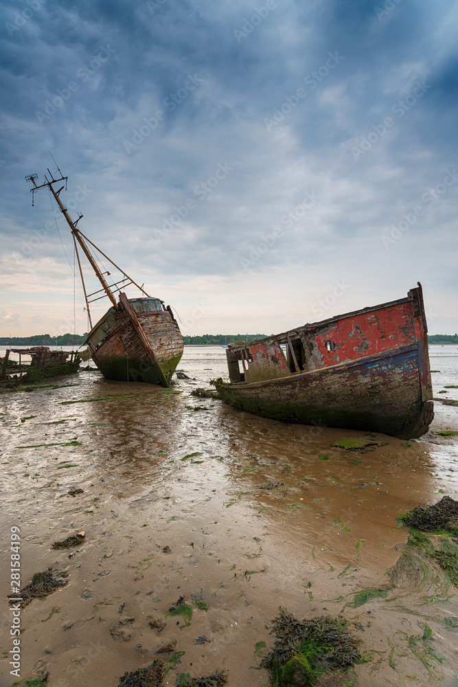 Abandoned fishing boats under a brooding sky